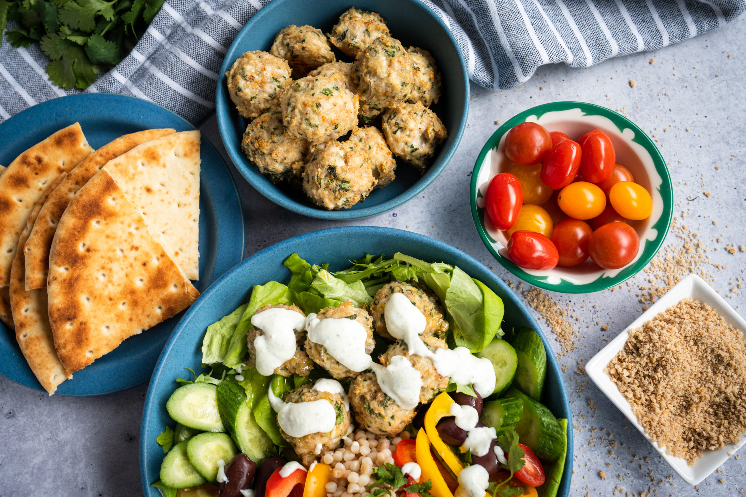 Greek chicken meatballs served over greens and grains