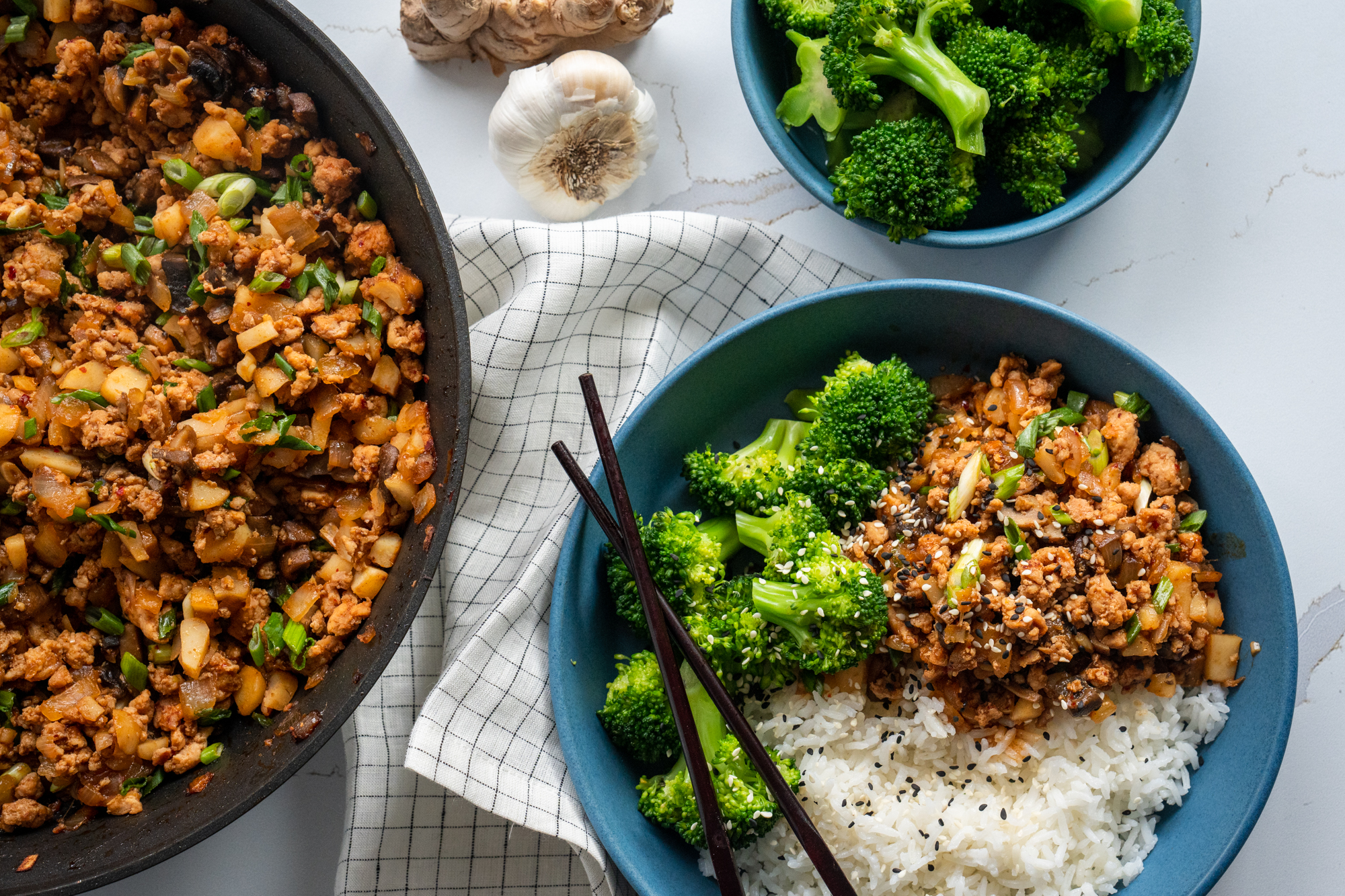 A bowl of rice, ginger ground chicken and broccoli with an Asian theme.