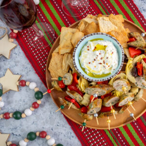 Holiday appetizer featuring Isernio's grilled spinach and feta sausages with Mediterranean dip and flavors.