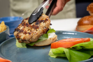 Grilled Isernio's chicken burger being served on a brioche bun