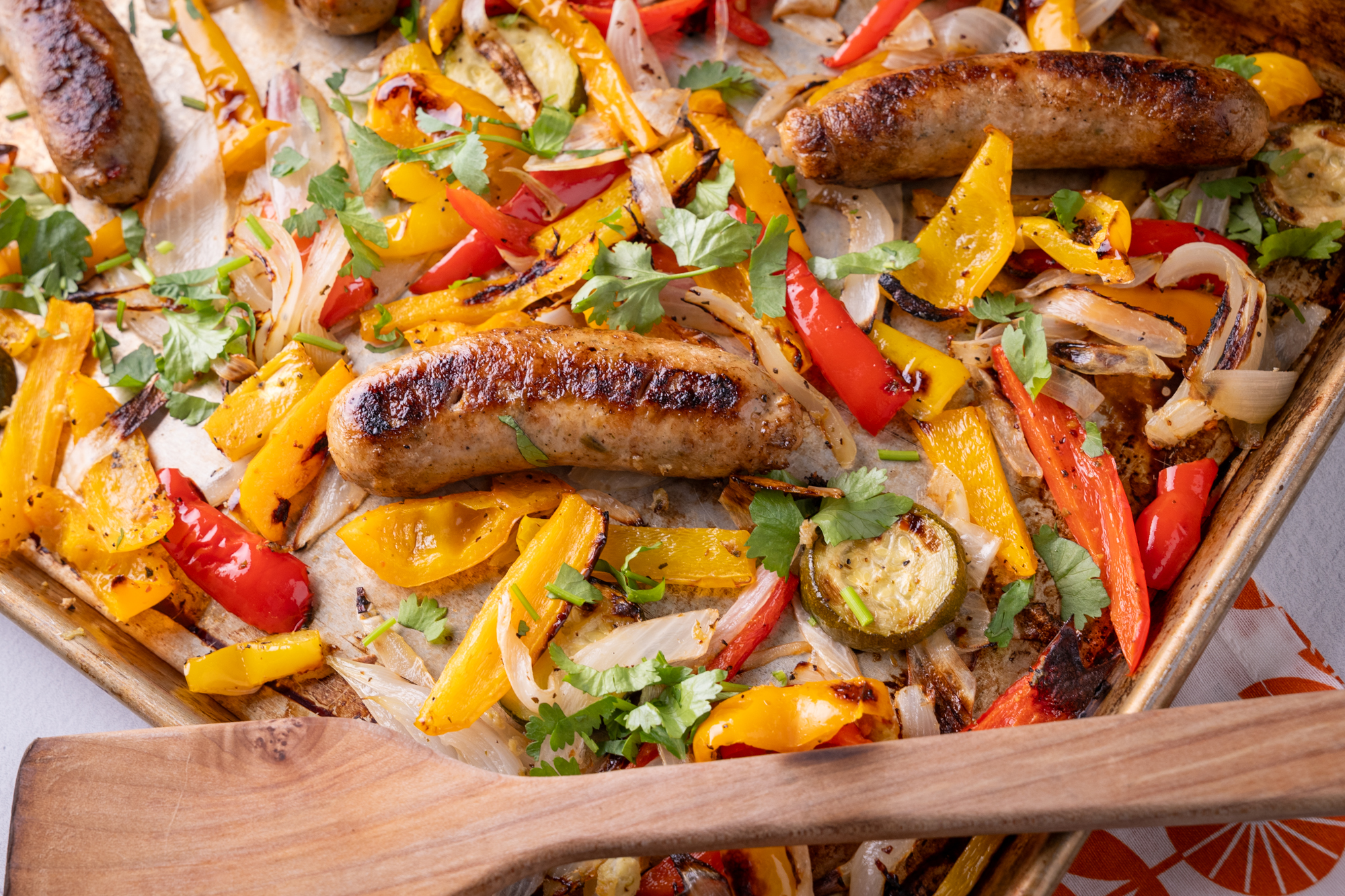 Sheet pan meal featuring browned Isernio's Italian sausages and roasted veggies