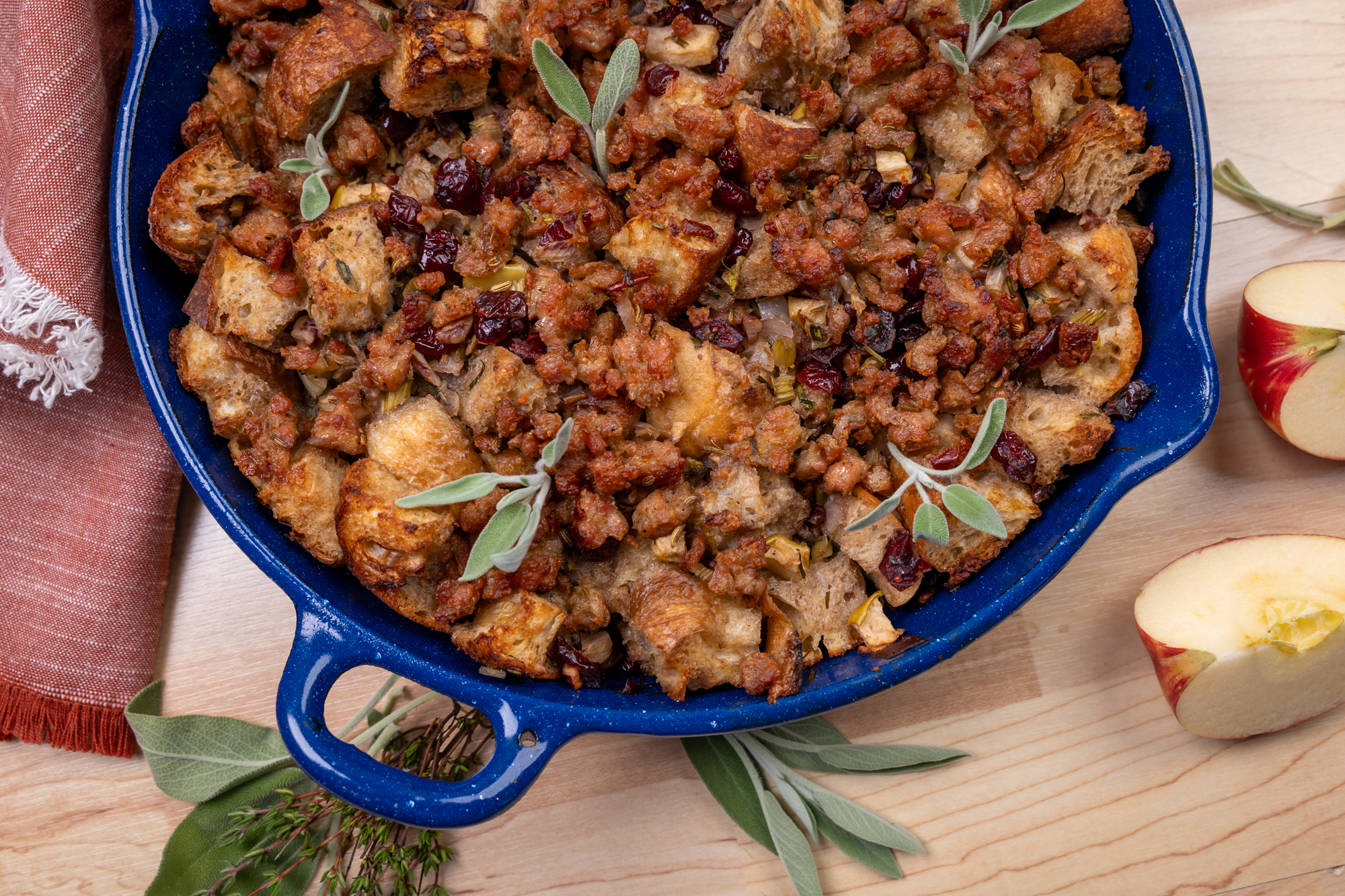 Blue pan with sausage and bread stuffing with apples and sage.