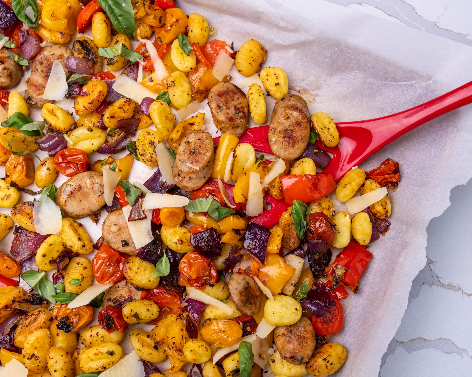 Sheet pan with Isernio's Italian Chicken Sausages, diced and roasted vegetables, and pan roasted gnocchi.